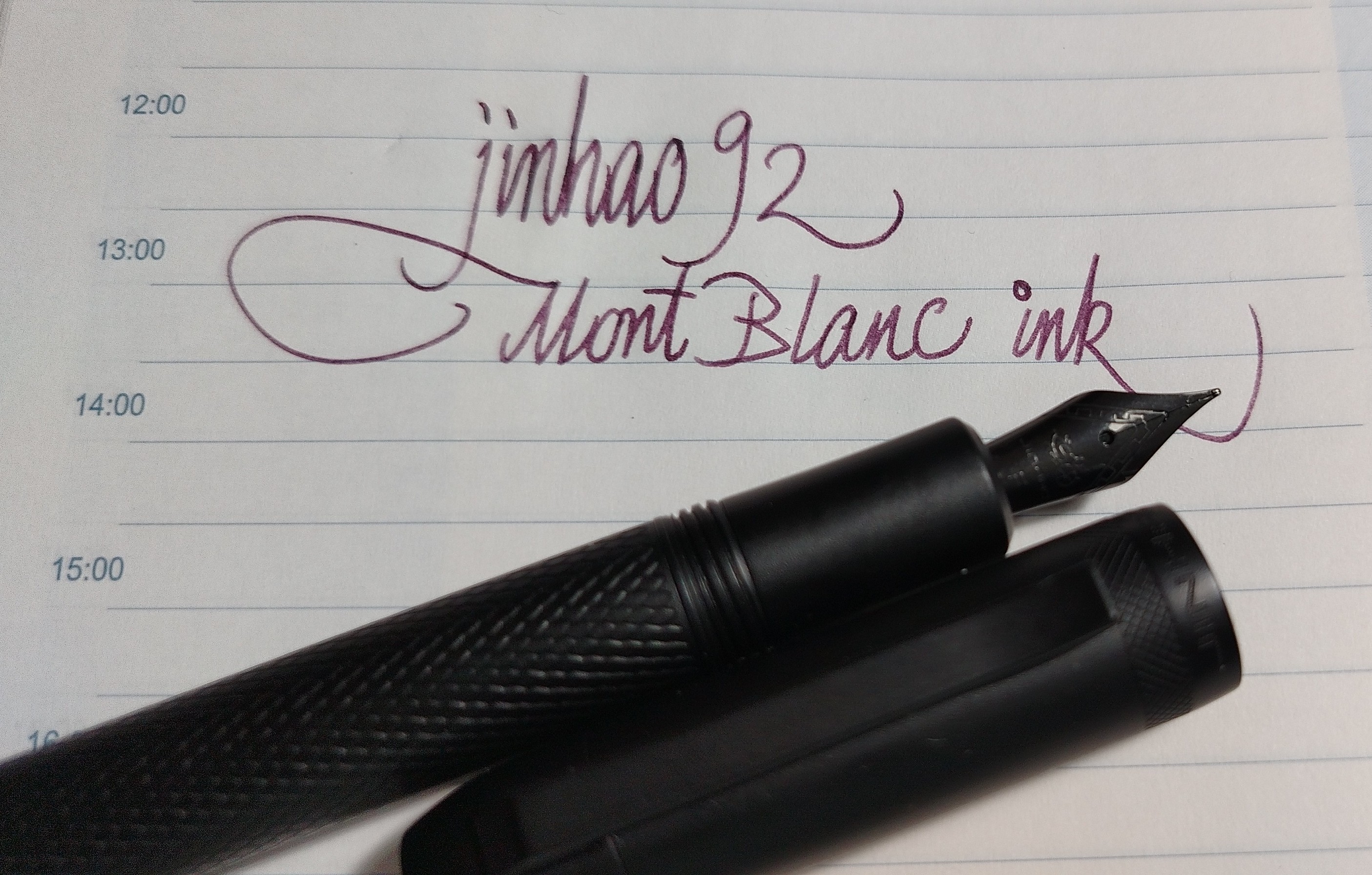 Black metal fountain pen on lined paper. "jinhao 92 Mont Blanc ink" written in italic hand.